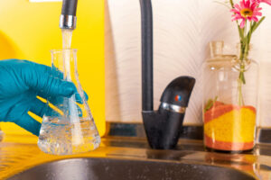 water purification specialist tap water pours into a glass flask(1)